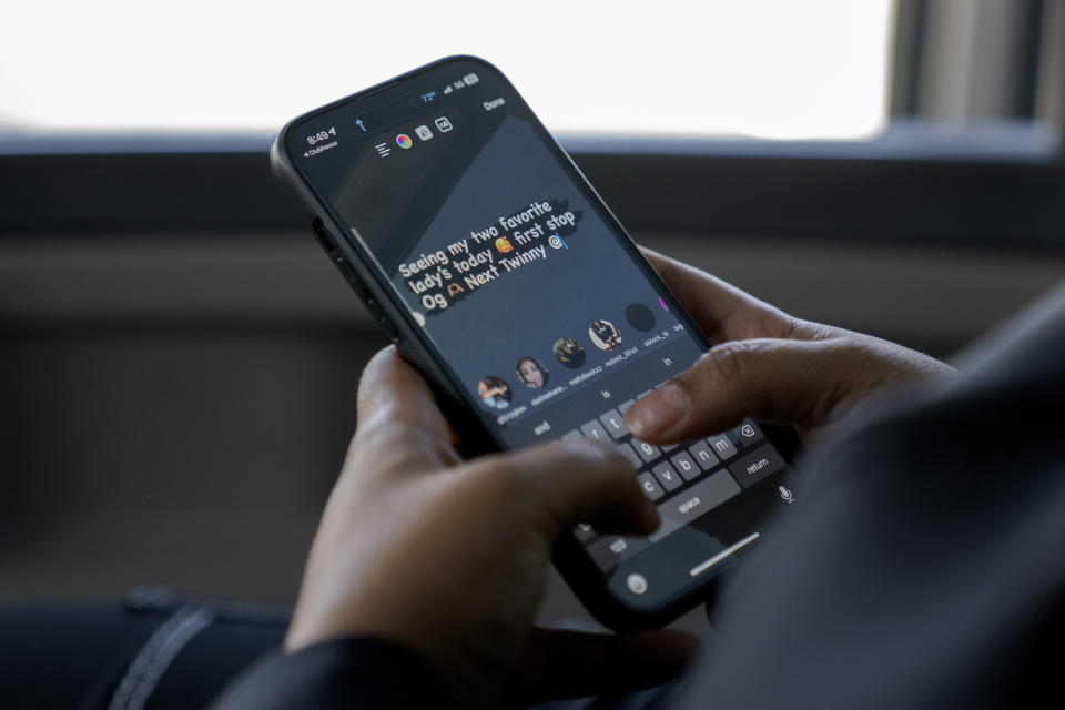 Nyia Pritchett, 27, types on her phone during a three-hour bus ride to Logan Correctional Center in downstate Illinois to visit her incarcerated mother Latonya Dextra, Saturday, May 20, 2023, in Illinois. Rare programs like the Reunification Ride, a donation-dependent initiative that buses prisoners' family members from Chicago to Illinois' largest women's prison every month so they can spend time with their mothers and grandmothers, are a crucial lifeline for families, prisoners say. (AP Photo/Erin Hooley)