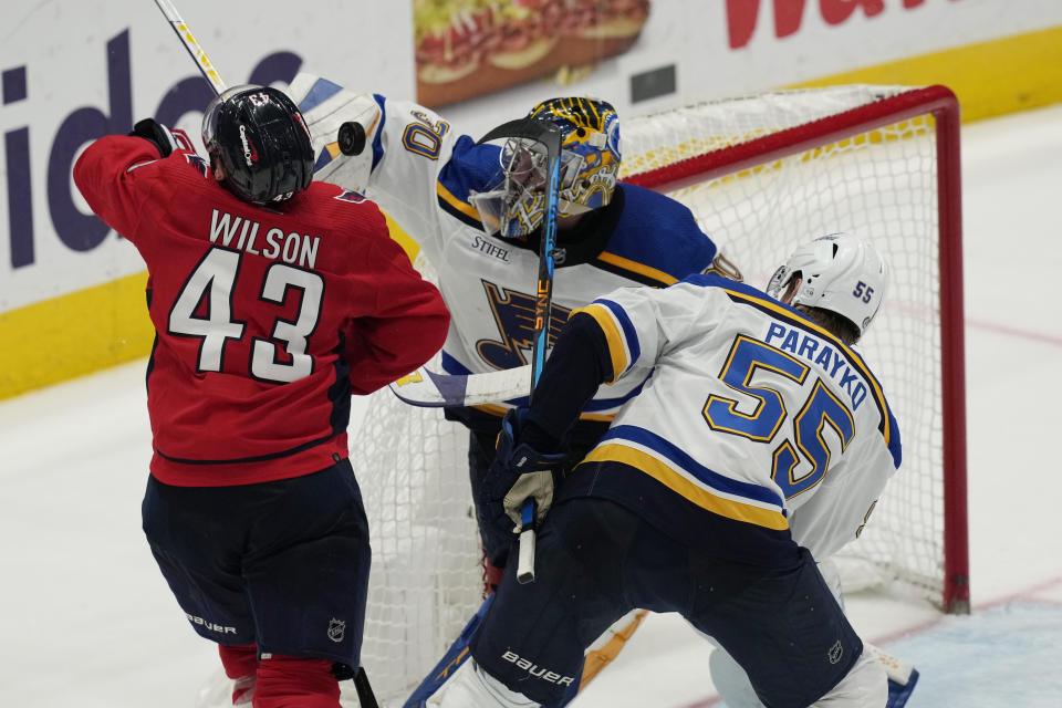 St. Louis Blues defenseman Colton Parayko (55) is called for high-sticking against Washington Capitals right wing Tom Wilson (43) as Blues goaltender Joel Hofer (30) defends the net during the third period of an NHL hockey game Friday, March 17, 2023, in Washington. (AP Photo/Carolyn Kaster)