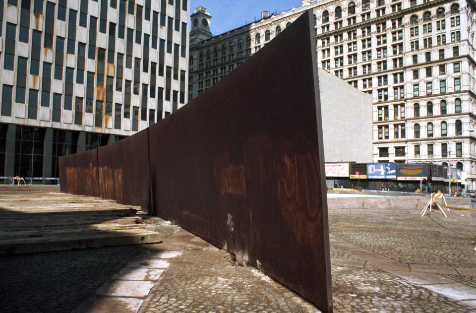 FILE - "Tilted Arc," a 12-foot-high, curving, inclined wall of rusting steel by famed American sculptor Richard Serra, awaits removal, March 11, 1989, at Federal Plaza in the Manhattan borough of New York. Serra, known for turning curving walls of rusting steel and other malleable materials into large-scale pieces of outdoor artwork that are now dotted across the world, died Tuesday, March 26, 2024, at his home in Long Island, N.Y. He was 85. (AP Photo/Mario Cabrera, File)