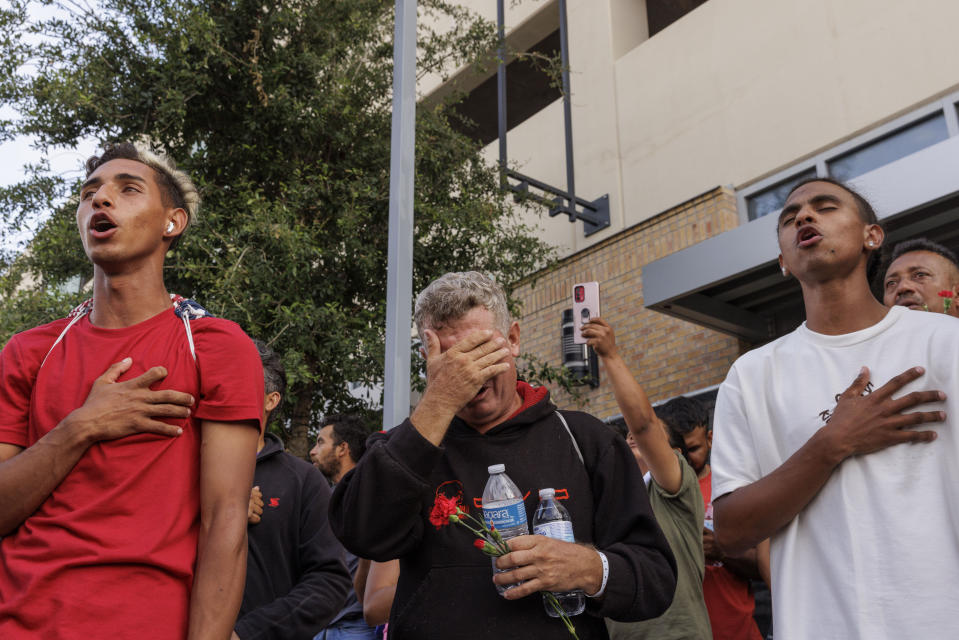 Migrants sing the Venezuelan national anthem during a vigil for the eight migrants that were killed and several others that were injured the day before while waiting at a bus stop, in Brownsville, Texas, Monday, May 8, 2023. (AP Photo/Michael Gonzalez)