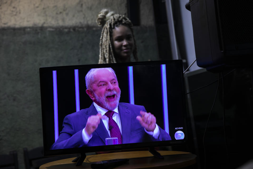 People watch a television interview of former president Luiz Inacio Lula da Silva, who is running again for president, with Jornal Nacional on TV Globo, outside a bar in Rio de Janeiro, Brazil, Thursday, August 25, 2022. Brazil's general elections are scheduled for Oct. 2. (AP Photo/Bruna Prado)