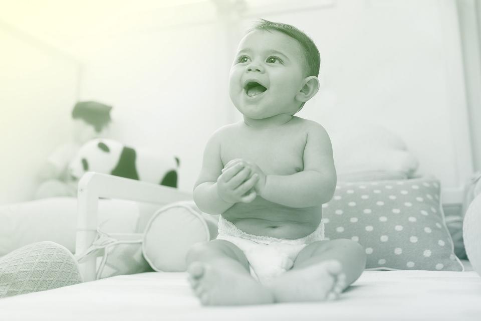 baby wearing diapers smiling with open mouth