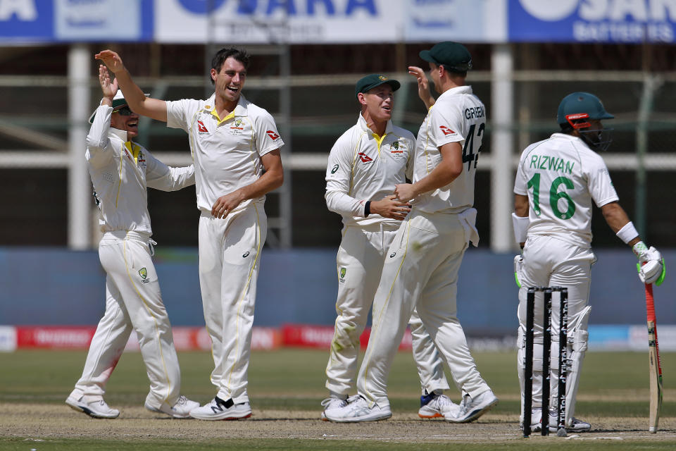 Australia's Pat Cummins, second left, celebrates with teammates after taking the wicket Pakistan Mohammad Rizwan on the third day of the second test match between Pakistan and Australia at the National Stadium in Karachi, Pakistan, Monday, March 14, 2022. (AP Photo/Anjum Naveed)
