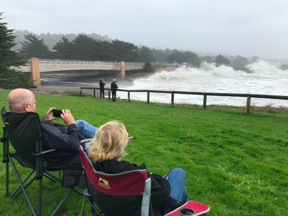 Mike and Cathy Cowles of Diamond Bar watch as waves crashed into the Leffingwell Landing bridge in Cambria at high tide Thursday, Dev. 28, 2023.