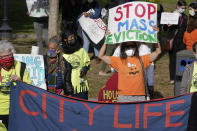 FILE - In this Oct. 11, 2020 file photo, protesters display placards while calling for support for tenants and homeowners at risk of eviction during a demonstration on the Boston Common, in Boston. The foreclosure moratorium, which bars foreclosures of federally backed mortgages, is set to end Saturday, July 31, 2021. Much like the federal eviction moratorium for rental units, it has been extended several times. (AP Photo/Steven Senne, File)