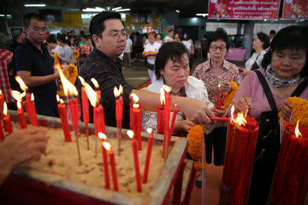"Drag Race Thailand" contestant Assadayut Khunviseadpong 'Natalia Pliacam' (2nd L) lights a candle at a Chinese shrine in Bangkok, Thailand March 18, 2018. REUTERS/Athit Perawongmetha