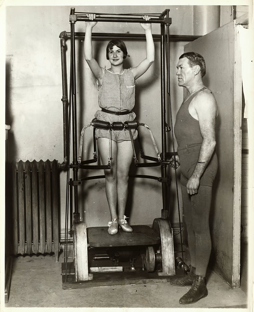 In Philadelphia, a woman works out on a machine designed to roll away fat while boxing champion "Philadelphia" Jack O'Brien looks on.<span class="copyright">George Rinhart/Corbis—Getty Images</span>