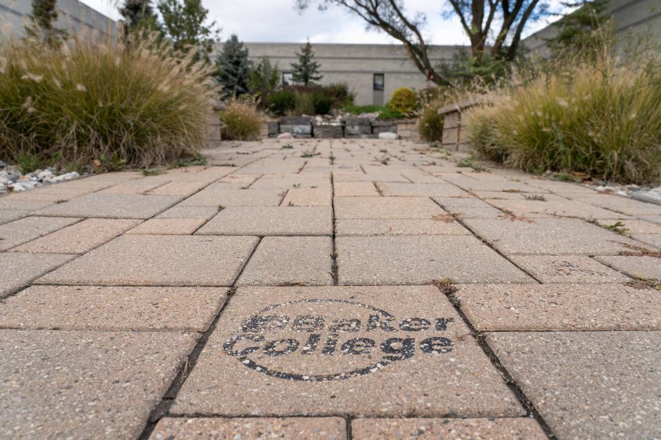 A brick with the Baker College logo remains in a garden area of the closed campus in Flint on Oct. 26, 2021.
