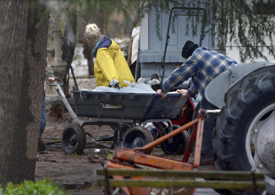 Residents move items on properties that flooded when a local creek overflowed in Lake Montezuma, Ariz., Tuesday, March 21, 2023. Evacuations were in effect in parts of north-central Arizona due to flooding. (Vyto Starinskas/The Daily Courier via AP)