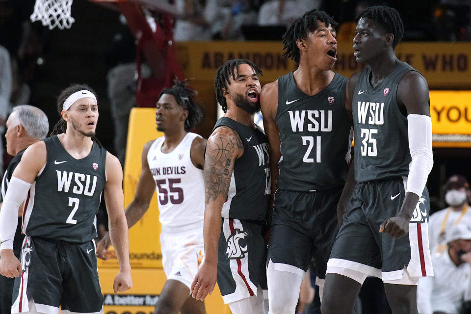 Washington State forward Mouhamed Gueye (35) celebrates with guard Michael Flowers (12), center Dishon Jackson (21), and guard Tyrell Roberts (2) after scoring against Arizona State during the second half of an NCAA college basketball game Wednesday, Dec. 1, 2021, in Tempe, Ariz. Washington State won 51-29. (AP Photo/Rick Scuteri)