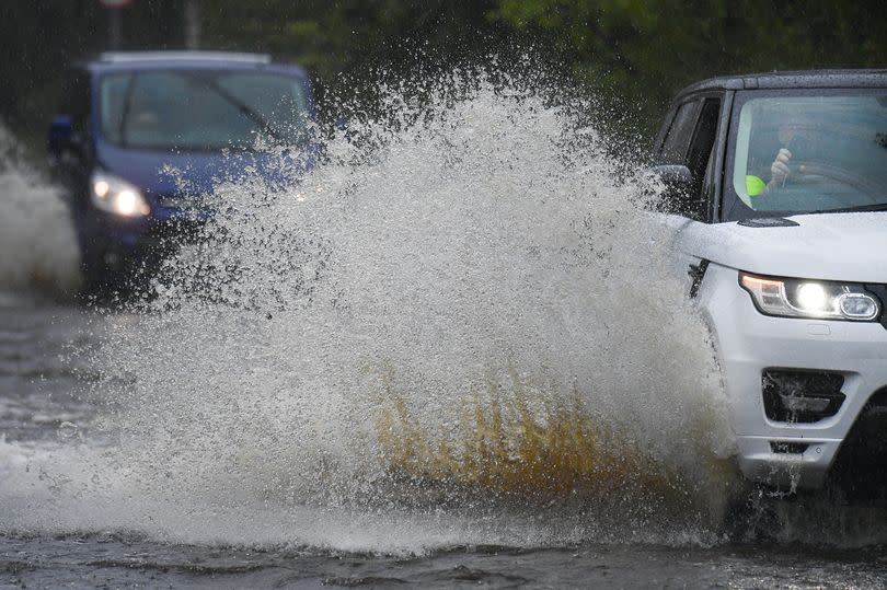 LOCHWINNOCH, SCOTLAND - AUGUST 04: Cars make their way through flood water following torrential rain on the A760 road near to Lochwinnoch on August 2, 2020 in Lochwinnoch, Scotland. The Scottish Environment Protection Agency (SEPA) has urged Scots to prepare for potential flooding around rivers, the sea and any surface water in areas in the west of Scotland. (Photo by Jeff J Mitchell/Getty Images)