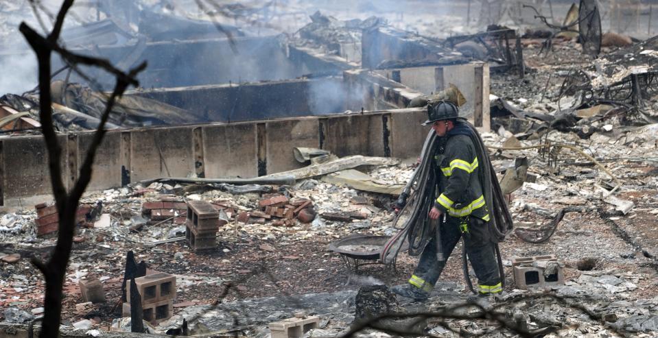A firefighter walks through the rubble of a home burned during the fires in Louisville Colorado, part of Boulder County.