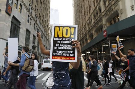 People march across a street holding placards during a protest against U.S. President Donald Trump's immigration policies in New York City, U.S., June 26, 2018. REUTERS/Brendan Mcdermid