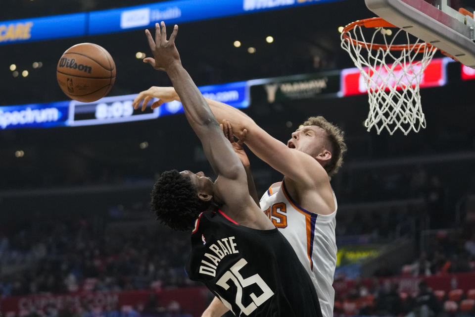 Phoenix Suns forward Torrey Craig, right, blocks a shot by LA Clippers forward Moussa Diabate (25) during the first half of an NBA basketball game in Los Angeles, Thursday, Dec. 15, 2022. (AP Photo/Ashley Landis)