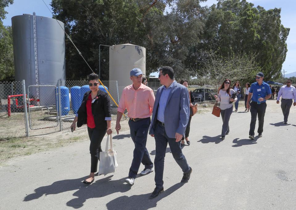 Tom Steyer, center with hat, tours the Desert Rose Mobile Home Park where the residential water is supplied by a domestic well in Thermal, March 29, 2019.