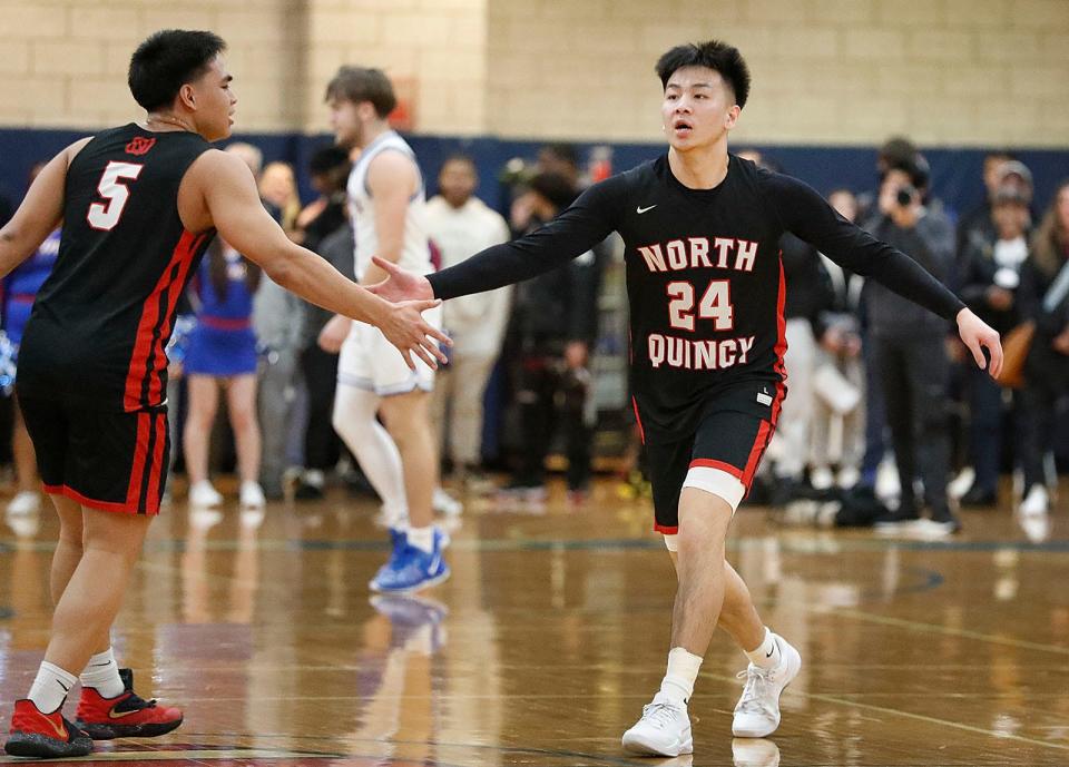 Raiders' Kobe Nguyen, right, gets props from AJ Arrazola on his first-half buzzer-beater. Quincy High boys basketball hosted North Quincy High on Friday, Feb. 9, 2024.