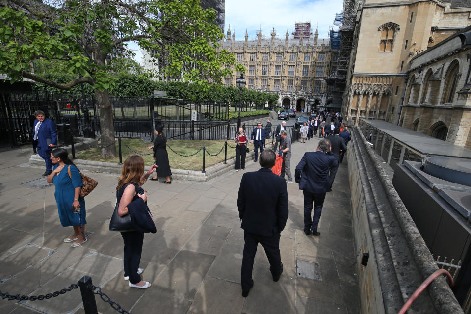 Members of Parliament queue outside the House of Commons in Westminster, London, as they wait to vote on the future of proceedings, amid a row over how Commons business can take place safely. (Photo: Jonathan Brady - PA Images via Getty Images)