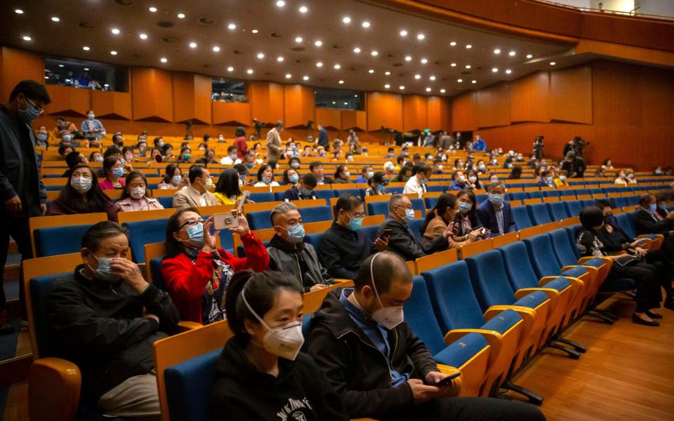 Audience members wearing face masks to protect against the coronavirus take their seats before a concert by the Wuhan Philharmonic Orchestra to open the Beijing Music Festival in Beijing - Mark Schiefelbein/AP Photo