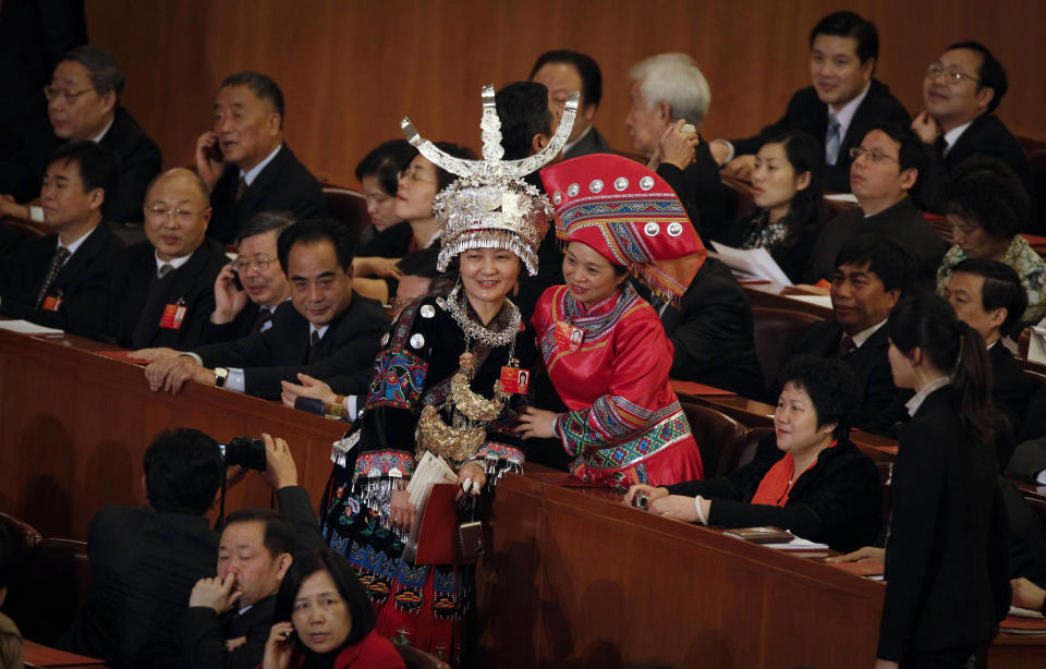 FILE - In this file photo taken Wednesday, March 14, 2012, female delegates in ethnic minority attire take pictures before the closing session of the National People's Congress in Beijing's Great Hall of the People in China. A glance at history suggests it's easier for a Chinese woman to orbit Earth than to land a spot on the highest rung of Chinese politics. In June, the 33-year-old Air Force major marked a major feminist milestone by becoming the first Chinese woman to travel in space. With a once-a-decade leadership transition set to kick off Nov. 8, many now are waiting to see if another ambitious Chinese female, State Councilor Liu Yandong, can win one of the nine spots at the apex of Chinese power. (AP Photo/ Vincent Thian, File)