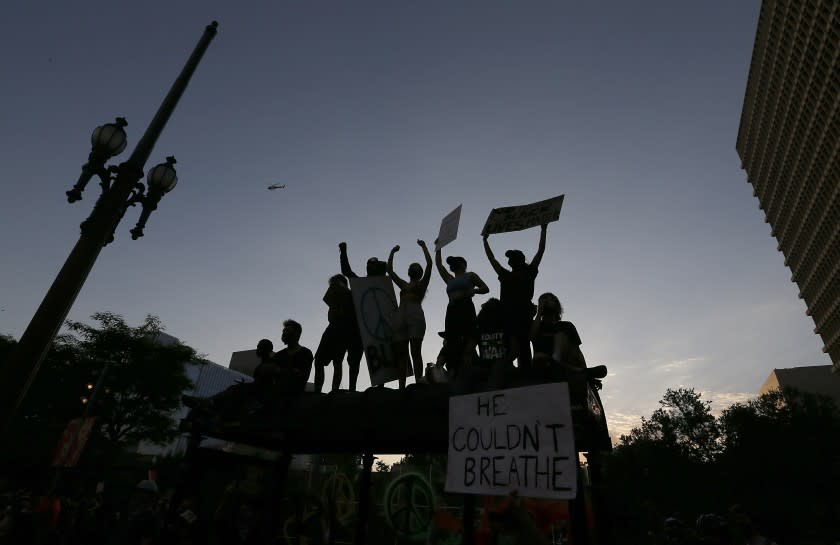 LOS ANGELES, CALIF. - JUNE 3, 2020. Protesters stand on top of a bus stop at the Los Angeles Civic Center to demonstrate for justice in the George Floyd murder by cop case on Wednesday, June 3, 2020. (Luis Sinco/Los Angeles Times)