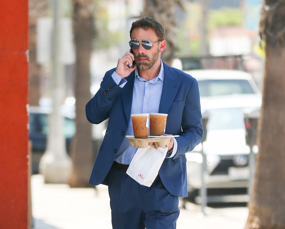 holding a cupholder with large iced coffees