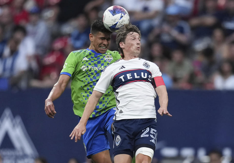 Seattle Sounders' Xavier Arreaga, back left, and Vancouver Whitecaps' Ryan Gauld vie for the ball during the first half of an MLS soccer match in Vancouver, British Columbia on Saturday, May 20, 2023. (Darryl Dyck/The Canadian Press via AP)