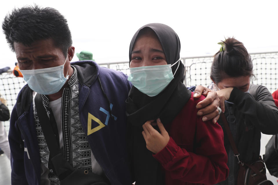 Relatives weep during a memorial ceremony for the victims of Sriwijaya Air Flight 182 on the deck of Indonesian Navy Ship KRI Semarang that sails in the Java Sea where the plane crashed on Jan. 9 killing all of its passengers, near Jakarta in Indonesia, Friday, Jan. 22, 2021. (AP Photo/Tatan Syuflana)