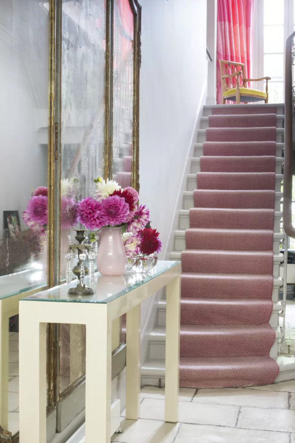<p> Think pink to elevate the look of a hallway. We love the way this shade follows through from the flowers, runner and up to the curtains at the top. As a side note, the glass on the top of the console also works to add reflection and life.&#xA0; </p> <p> &#x2018;Mirrors are always a good go-to in a hallway but nothing beats a vase of flowers on a console to add life,&#x2019; advises interior designer&#xA0;Samantha Todhunter. &#x2018;We used a vibrant pink stair runner to create a focal point at the end of the hallway.&#x2019; </p>