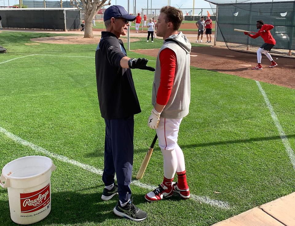 Brett Butler, a renowned bunting specialist, talks with Cincinnati Reds center fielder TJ Friedl (29), Tuesday, Feb. 27, 2024, at the team’s spring training facility in Goodyear, Arizona.