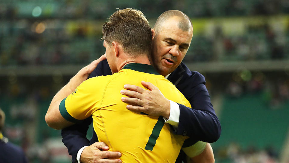 Wallabies captain Michael Hooper and coach Michael Cheika embrace after the defeat to England.