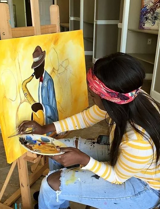 Self-taught artist Theresa Cates paints a musician playing a large saxophone. Music in her life has inspired many of Cates' paintings.