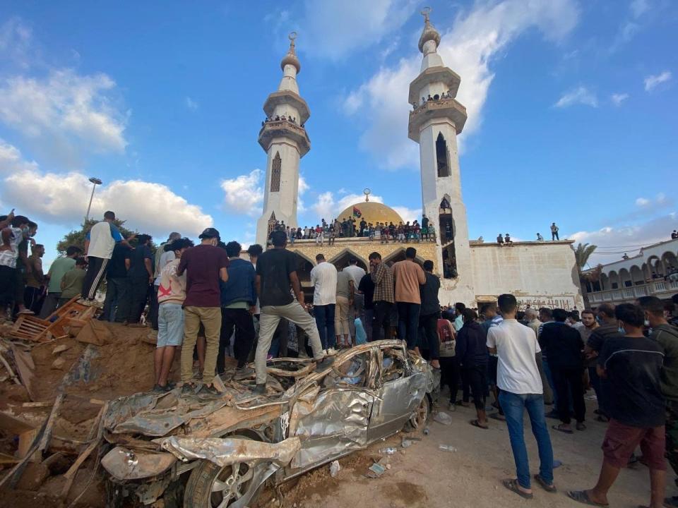 Demonstrators stand on a damaged as a part of a protest outside of the Al-Sahaba mosque.