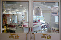 Signs advising vaccination and face mask requirements and no indoor dining are shown on the door of an In-N-Out restaurant in San Francisco's Fisherman's Wharf, Wednesday, Oct. 20, 2021. The In-N-Out hamburger chain is sizzling mad after San Francisco shut down its indoor dining for refusing to check customers' vaccination status. The company's Fisherman's Wharf location, its only one in San Francisco, was temporarily shut by the Department of Public Health on Oct. 14. (AP Photo/Jeff Chiu)