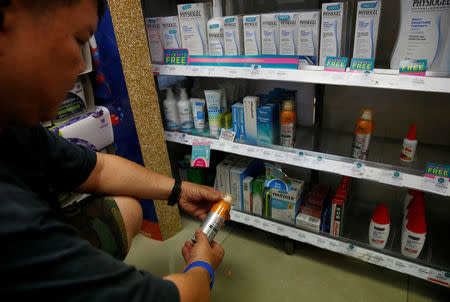 A man shops for insect repellent in a pharmacy at an area where locally transmitted Zika cases were discovered in Singapore