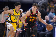 Indiana Pacers guard Ben Sheppard (26) defends Atlanta Hawks guard Bogdan Bogdanovic (13) during the first half of an NBA basketball game in Indianapolis, Sunday, April 14, 2024. (AP Photo/Michael Conroy)