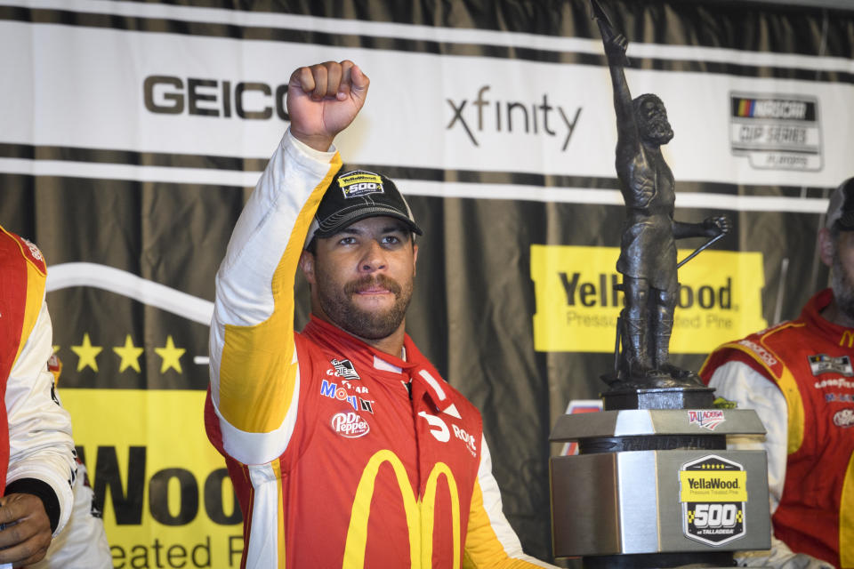 Bubba Wallace celebrates next to the trophy after winning a NASCAR Cup series auto race Monday, Oct. 4, 2021, in Talladega, Ala. The race was stopped mid-race due to rain. (AP Photo/John Amis)