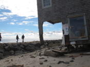 In this Oct. 31, 2012 photo, people walk along a rock wall in Bay Head N.J. two days after Superstorm Sandy hit. On the 10th anniversary of the storm, government officials and residents say much has been done to protect against the next storm, but caution that much more still needs to be done to protect against future storms. (AP Photo/Wayne Parry)