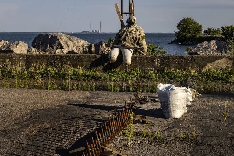 Un soldado se sienta en territorio controlado por Ucrania cerca de Nikopol, al otro lado del río Dniepro desde la planta de energía nuclear de Zaporizhzhia.

