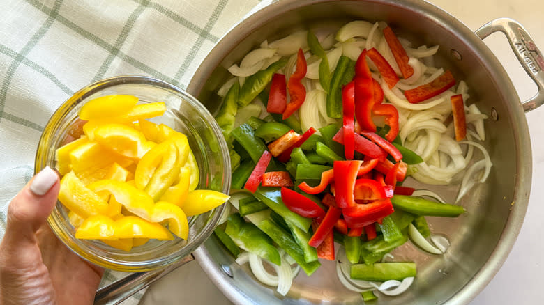 adding yellow peppers to pan