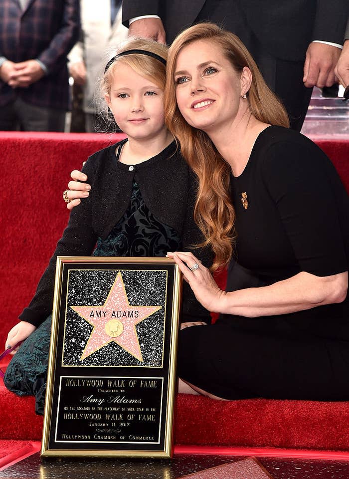Amy Adams (R) and Aviana kneeling and posing for photos at Amy's star ceremony on the Hollywood Walk of Fame