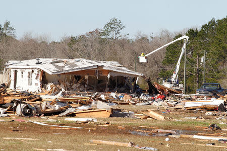 Power workers work on reinstalling power lines at Sunshine Acres mobile home park after a tornado struck the mobile home park in Adel, Georgia, U.S., January 24, 2017. REUTERS/Tami Chappell