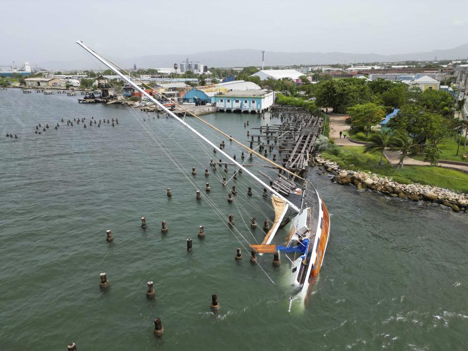 A boat damaged by Hurricane Beryl lays on its side at a dock in Kingston, Jamaica, Thursday, July 4, 2024. (AP Photo/Leo Hudson)