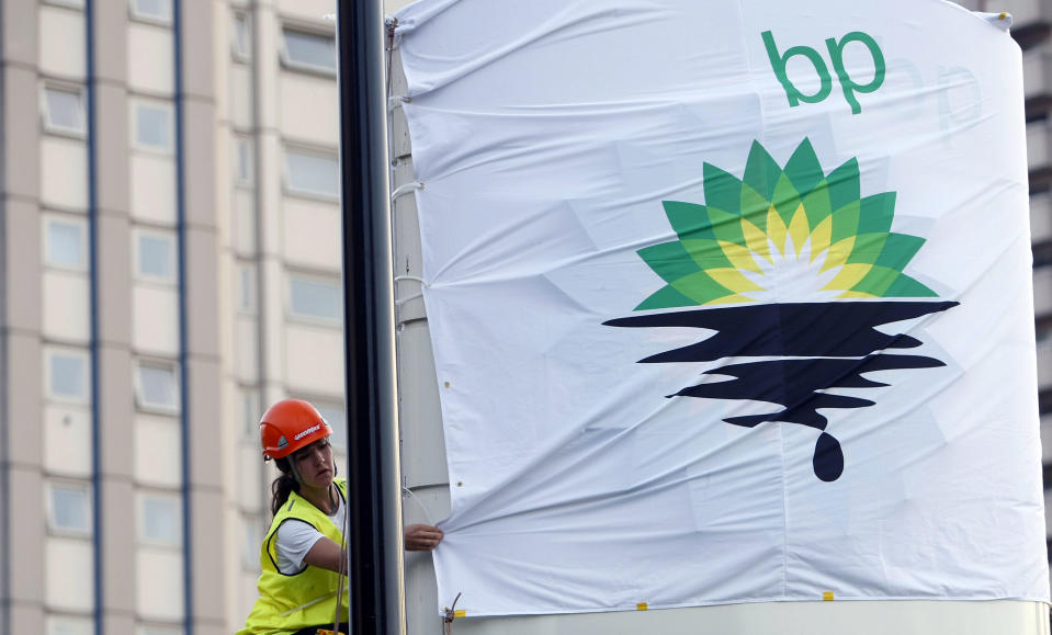 FILE-In this Tuesday, July 27, 2010, file photo, a Greenpeace activist puts up a banner as they block off a British Petroleum fuel station in protest as the BP board announce their annual results, in London. A BP executive has been indicted on charges that he lied to authorities about his work estimating the rate oil was flowing during the 2010 Gulf oil spill disaster. (AP Photo/Alastair Grant, FIle)