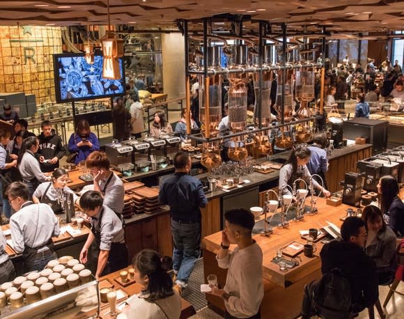 Baristas make drinks for customers in the middle of the new Starbucks Reserve Roastery in Shanghai.