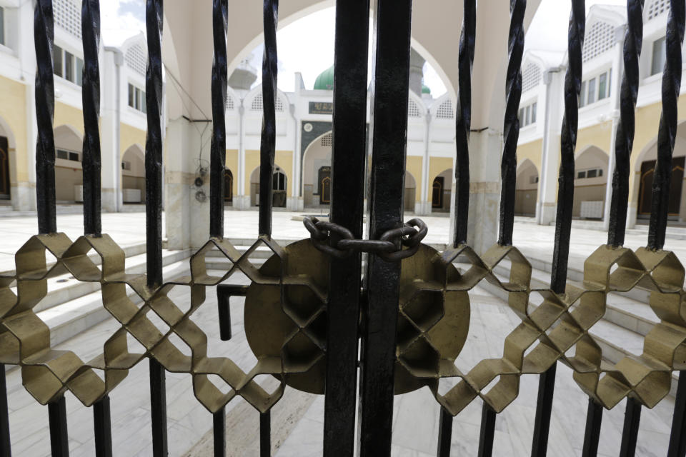 Th locked gates of the Jamie Mosque in Nairobi, Kenya Friday, March 20, 2020, as prayers is suspended until further notice due to coronavirus. For most people, the new coronavirus causes only mild or moderate symptoms such as fever and cough and the vast majority recover in 2-6 weeks but for some, especially older adults and people with existing health issues, the virus that causes COVID-19 can result in more severe illness, including pneumonia. (AP Photo/Khalil Senosi)