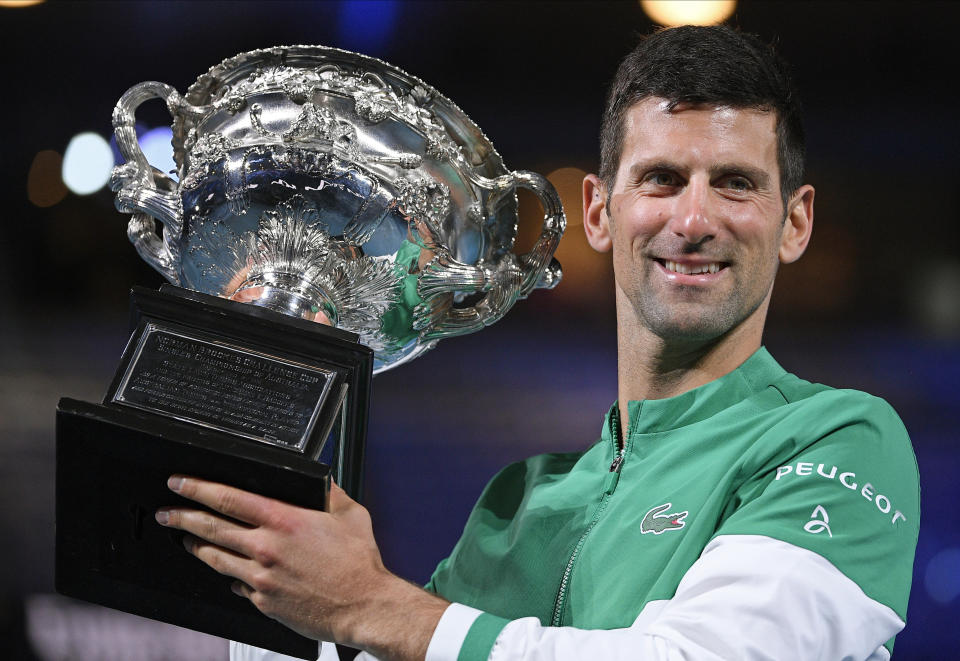 FILE -Serbia's Novak Djokovic holds the Norman Brookes Challenge Cup after defeating Russia's Daniil Medvedev in the men's singles final at the Australian Open tennis championship in Melbourne, Australia, Sunday, Feb. 21, 2021.(AP Photo/Andy Brownbill, File)