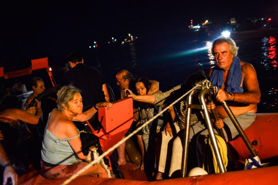 Rescuers and volunteers help local people evacuate the Greek village of Mati (Picture: Getty)