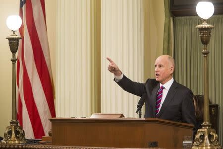 California Governor Jerry Brown points to his relatives in the gallery at his historic fourth inauguration at the State Capitol in Sacramento, January 5, 2015. REUTERS/Max Whittaker