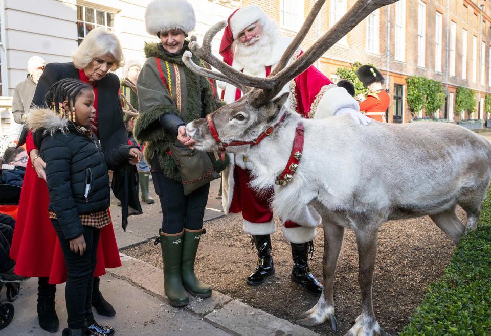 Camilla, queen consort, and Mayann MacNeil-Thompson, 7, meet Blixen the reindeer and Santa at Clarence House in London on Dec. 7.