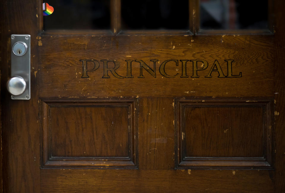 Wooden door with the word "PRINCIPAL" engraved on it and a security keypad to the side